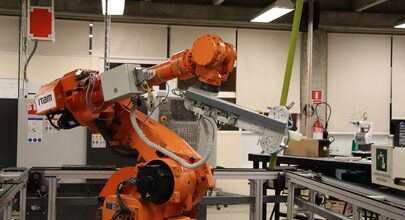 An industrial robot arm on an instrumented workcell inside a research lab